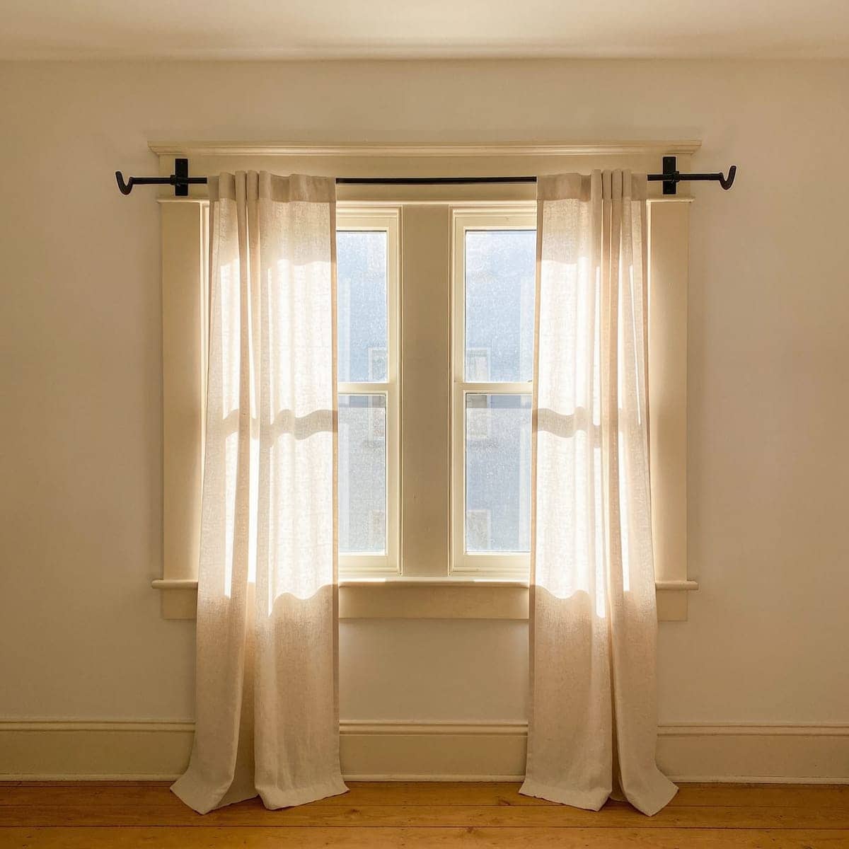 no drill curtain bracket tapped into the top of a wooden window frame