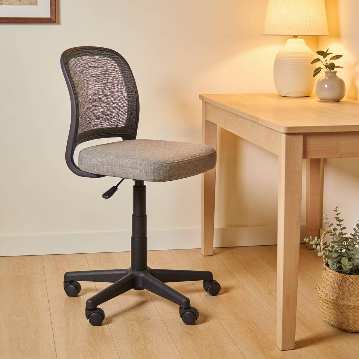 small armless task chair tucked fully under a narrow desk