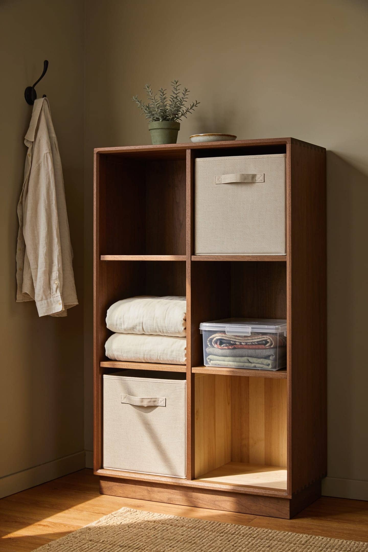 closet shelf lined with matching fabric storage bins and clear lidded boxes