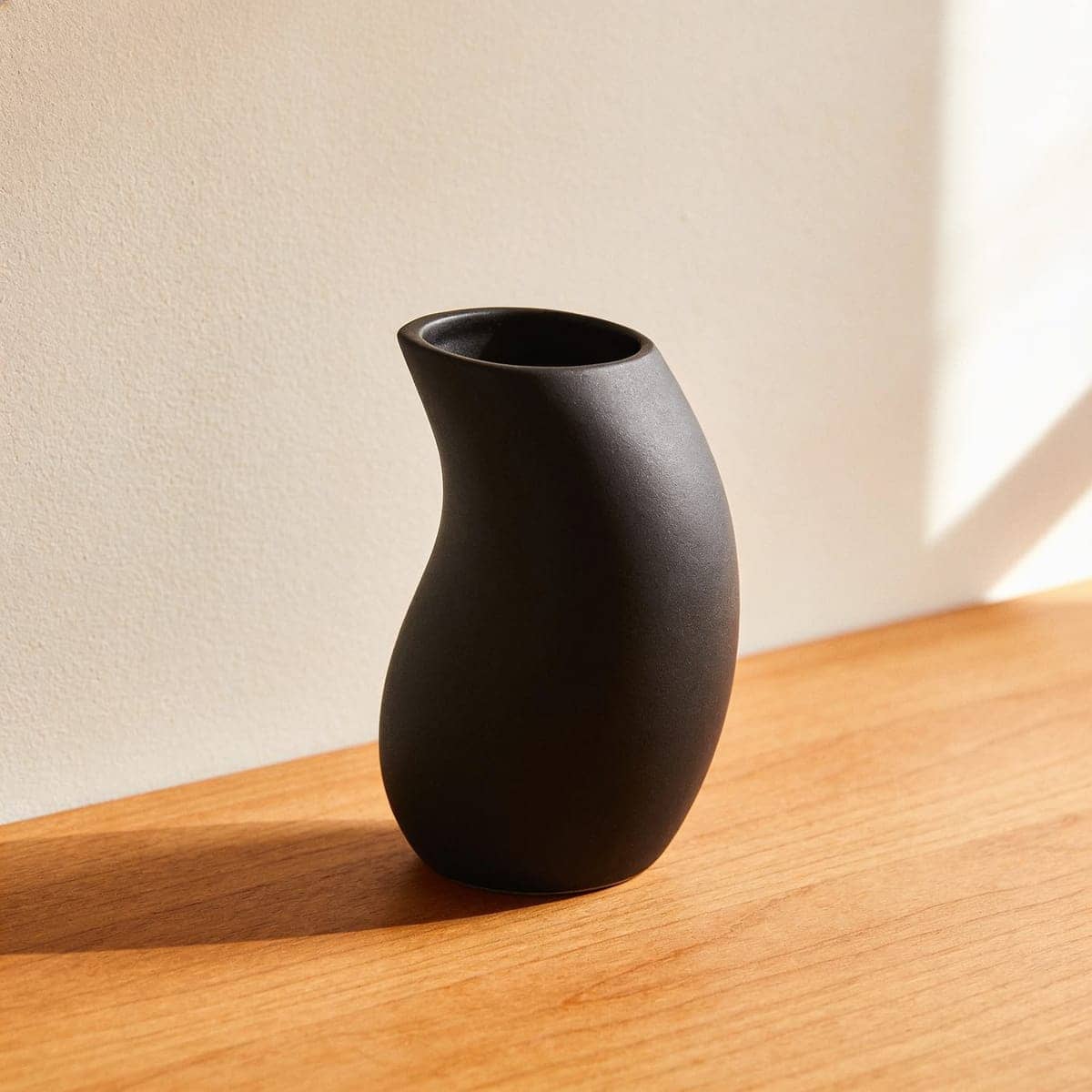matte black sculptural ceramic vase with an organic curved shape