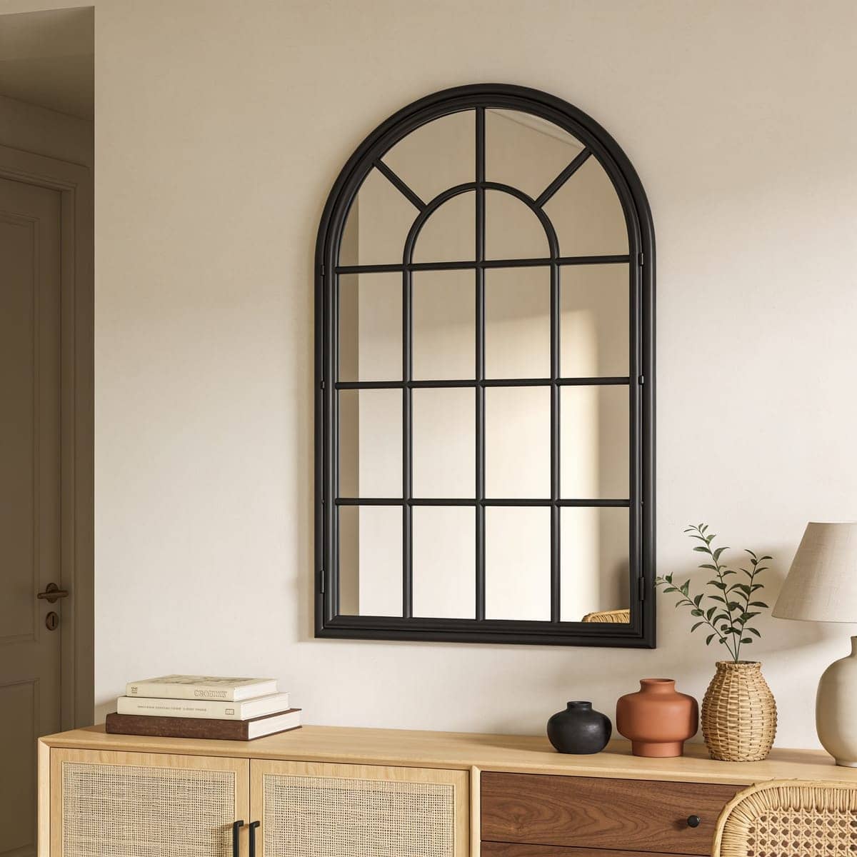 arched windowpane mirror with black mullions on an interior wall