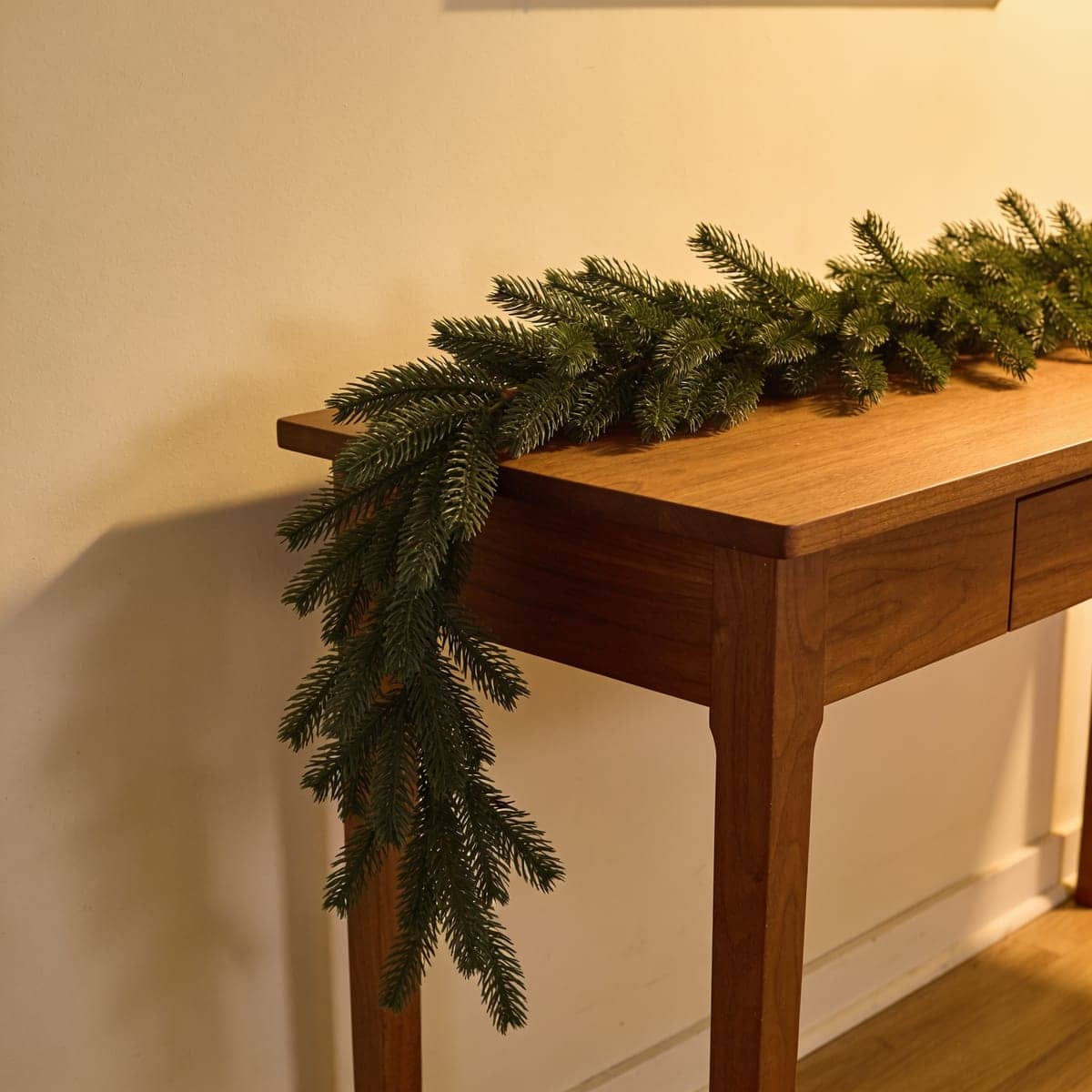 faux cedar garland with soft draping foliage on a console