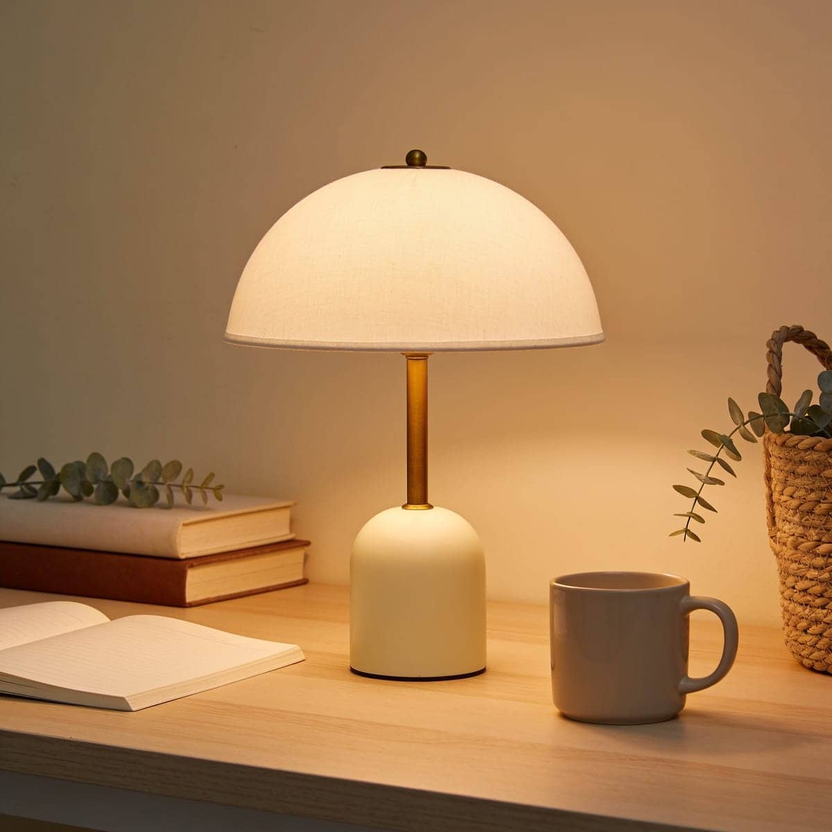 small cordless rechargeable desk lamp glowing on a bare table
