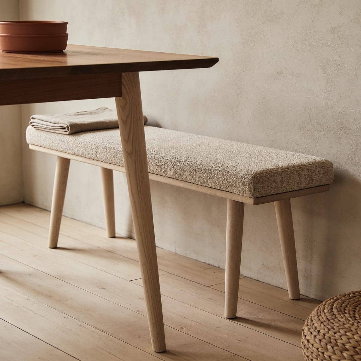 upholstered dining bench tucked under a wood dining table