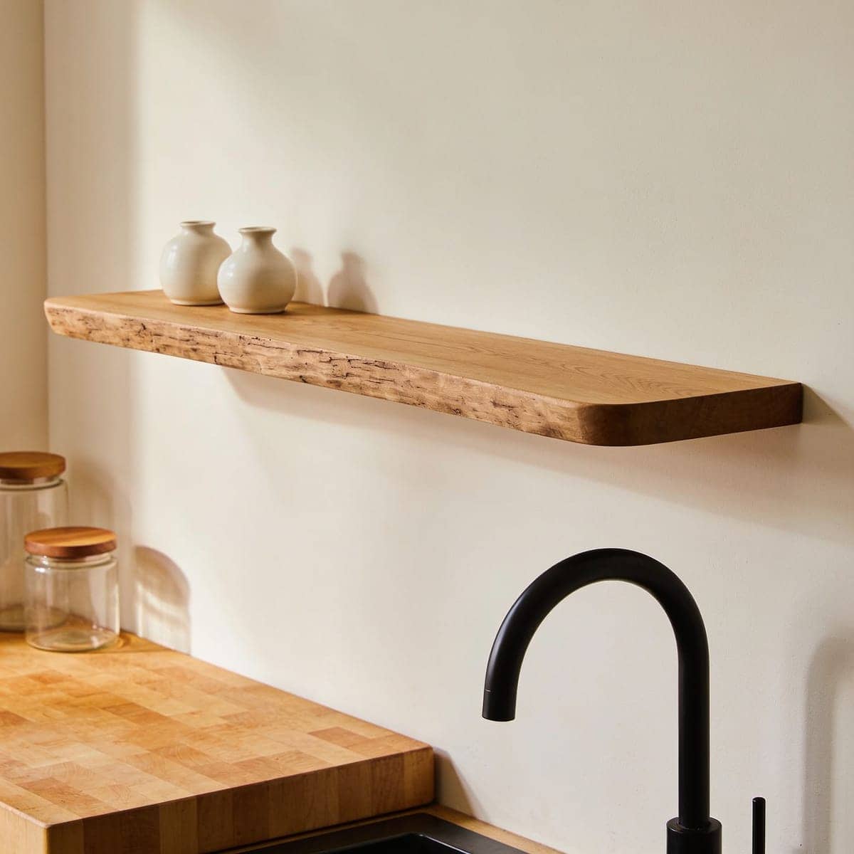 thick solid wood floating shelf with visible grain on a warm wall