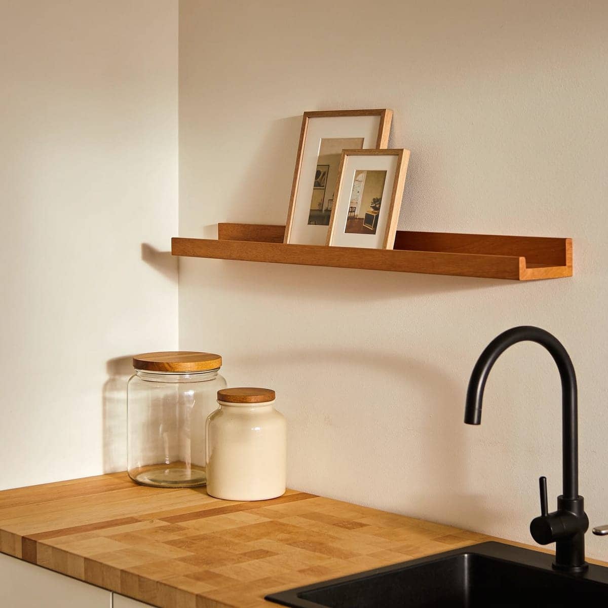 narrow picture ledge shelf with a front lip holding leaning frames