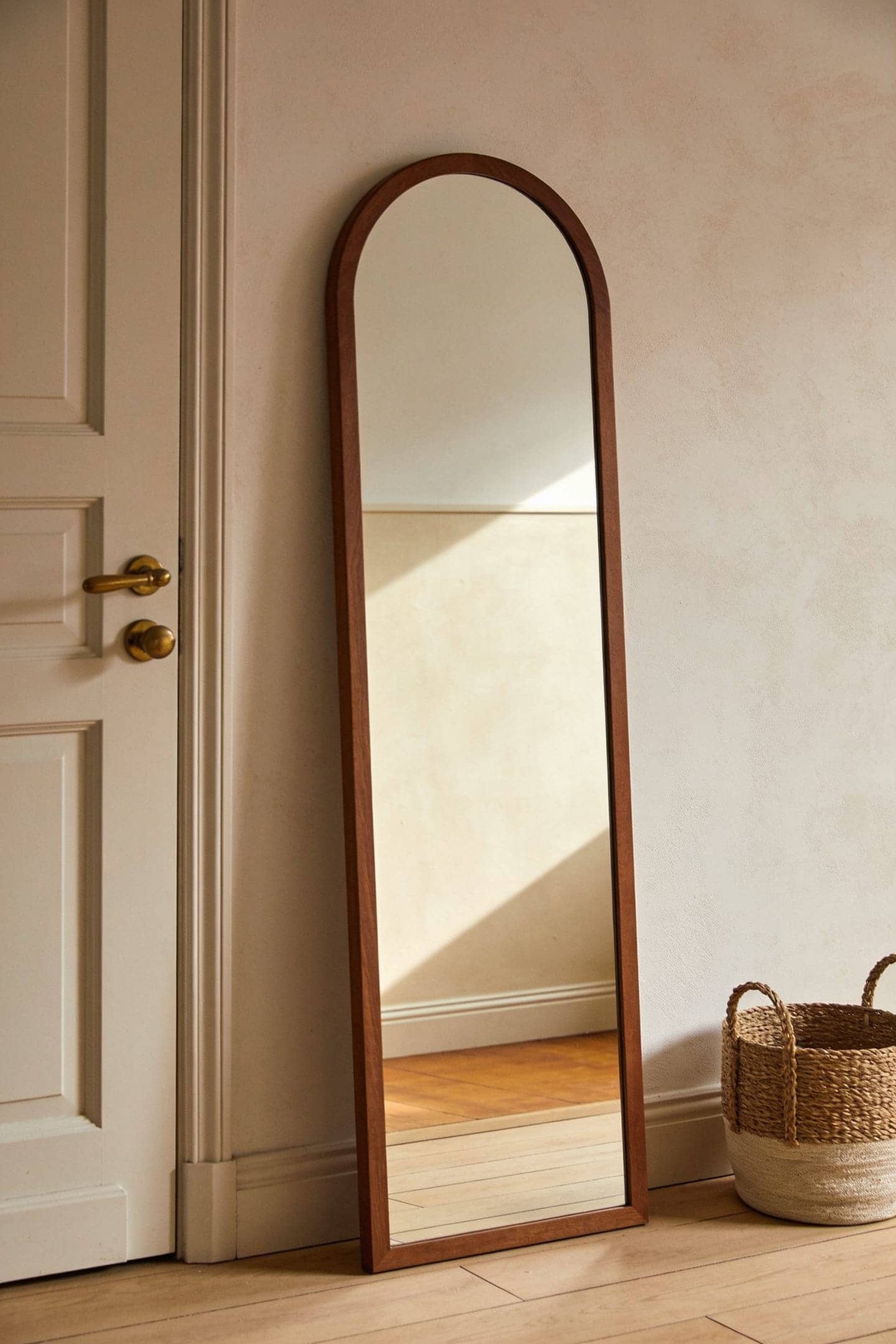 full length mirror leaning against the wall beside an apartment front door