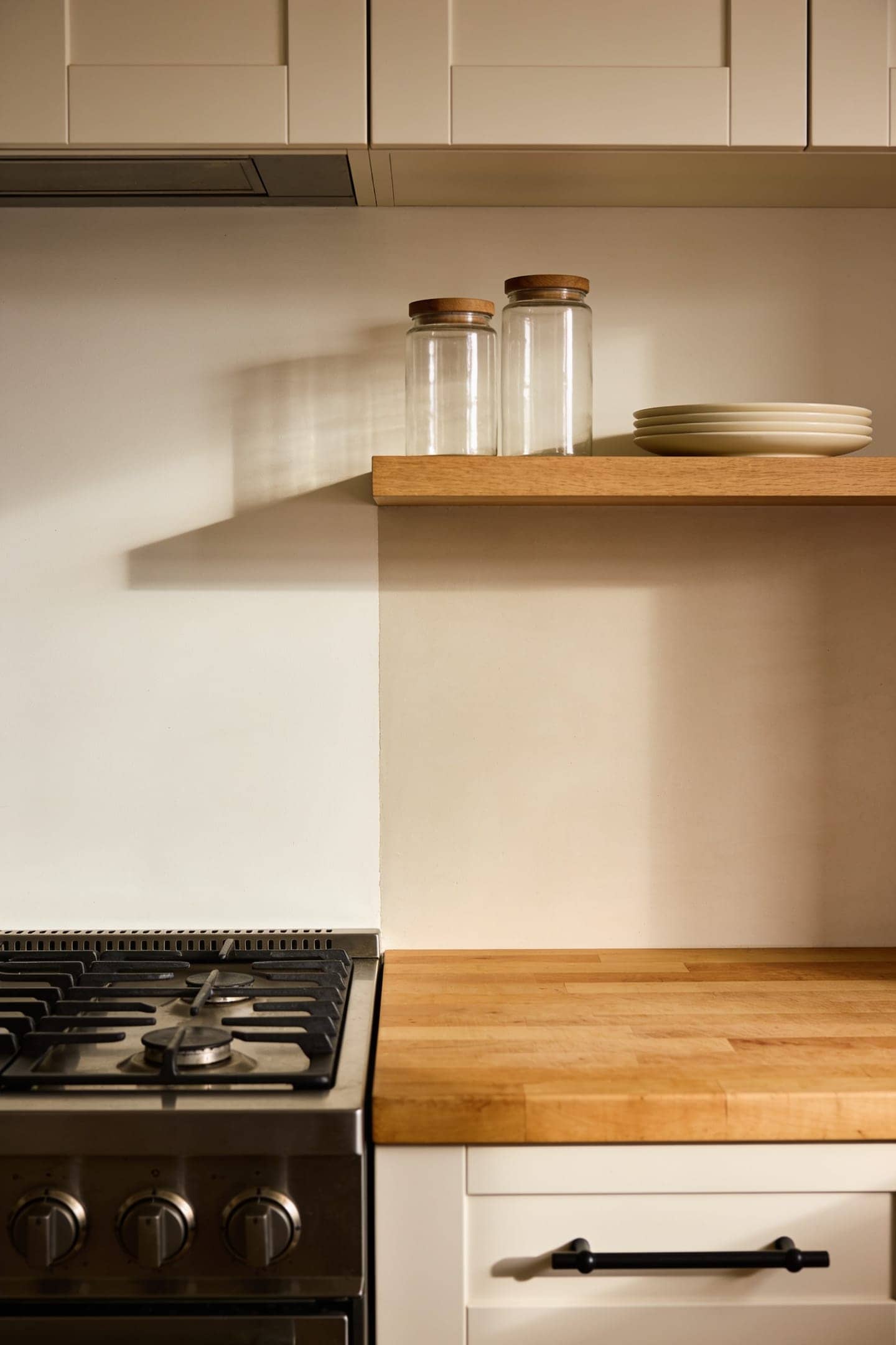 open shelves mounted beside a range hood rather than above the cooktop