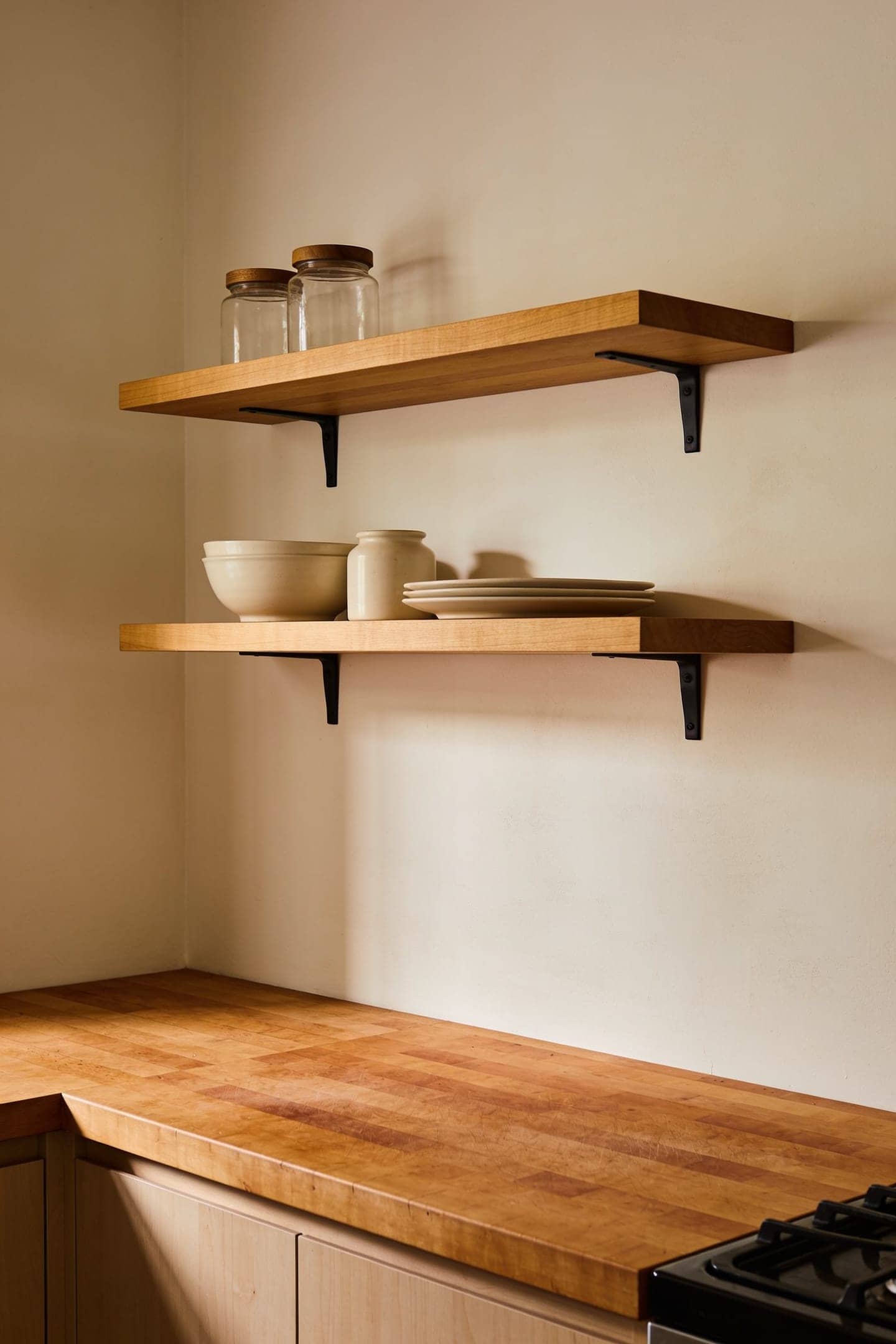 a single short pair of open shelves on one section of kitchen wall