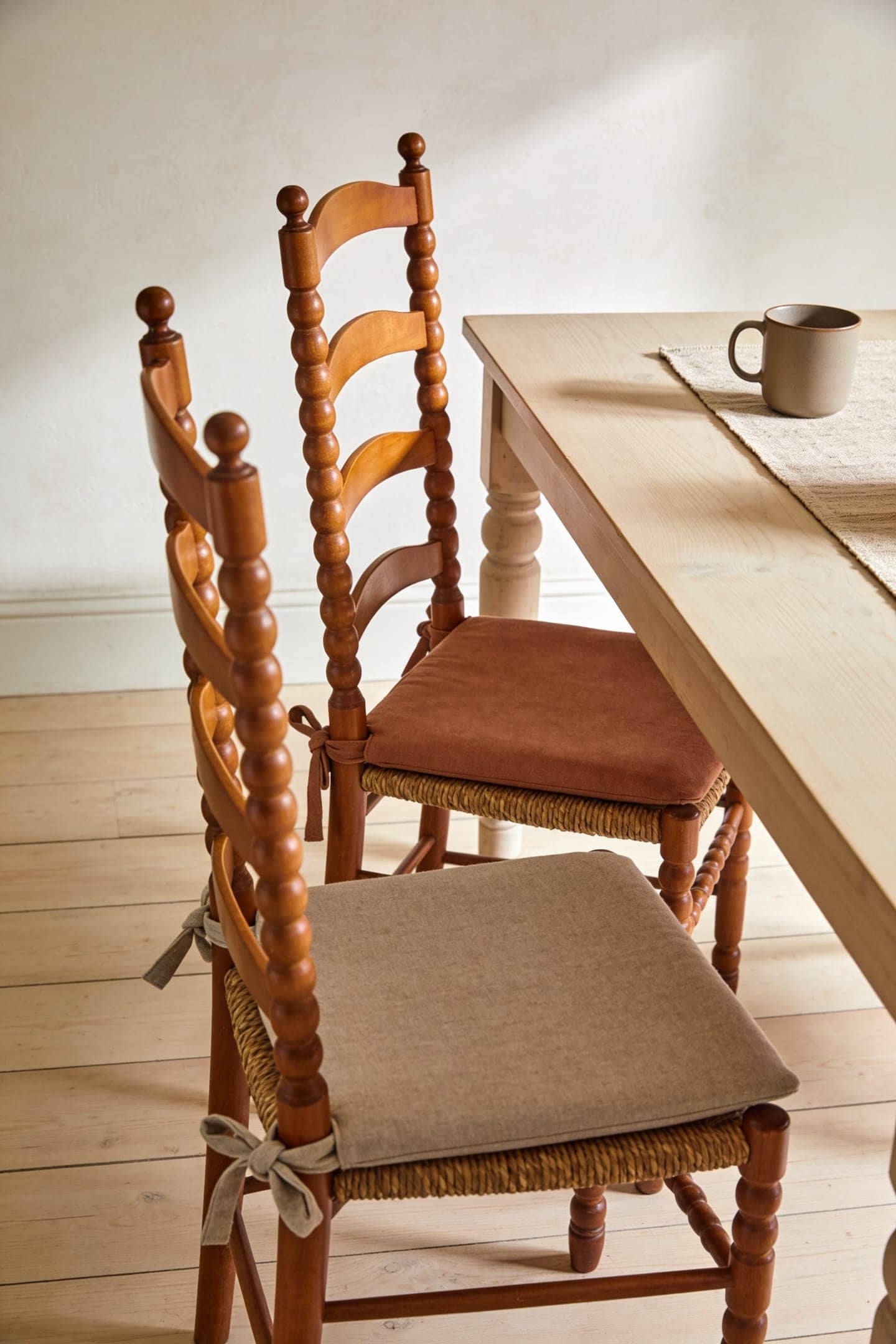 tie on seat cushions on wood dining chairs at a small table