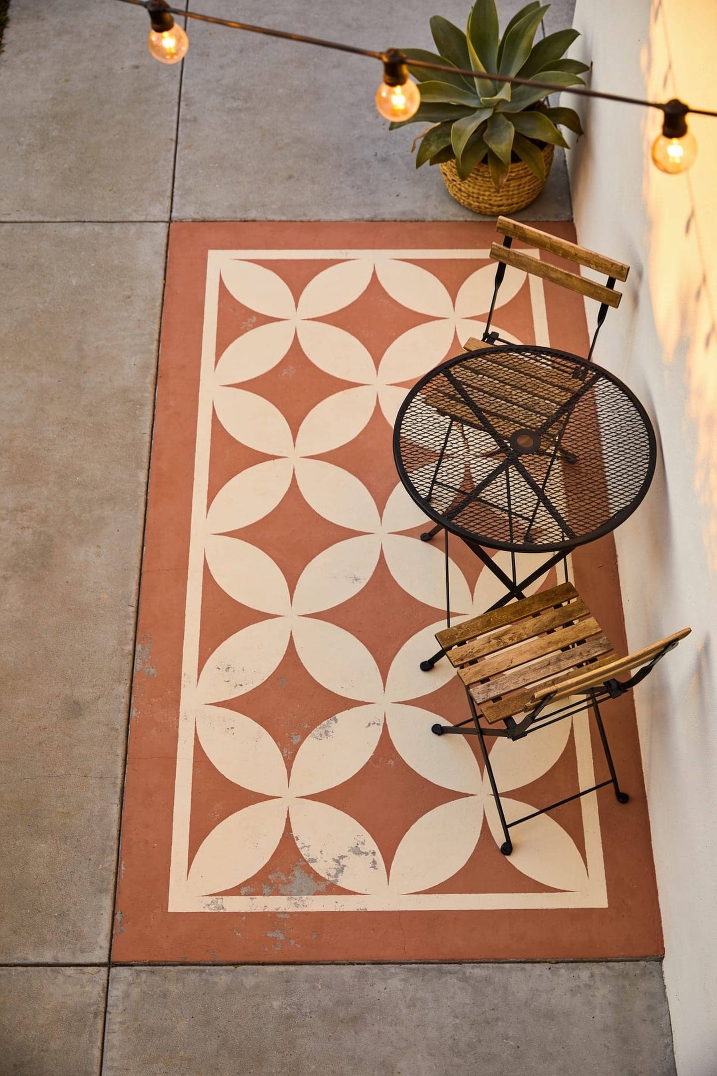 stenciled painted rug on a small concrete patio